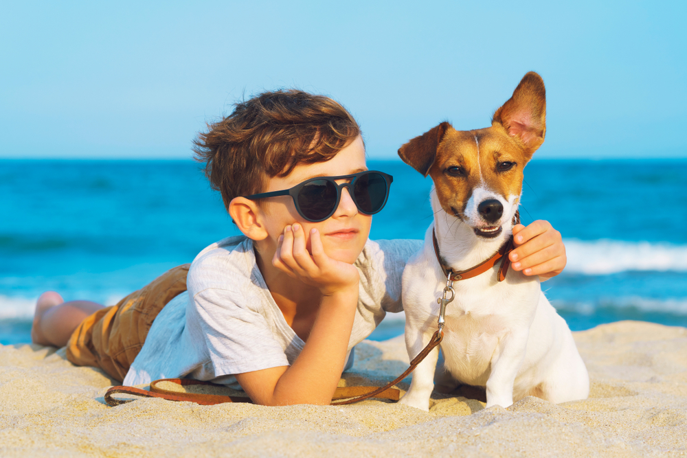 Photo of a Child with His Pup During a Outer Banks Dog-Friendly Vacay