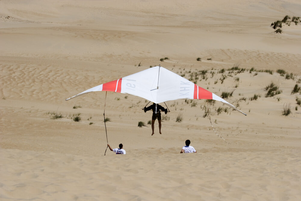 A photo of someone hang gliding on Kill Devil Hills sand dunes