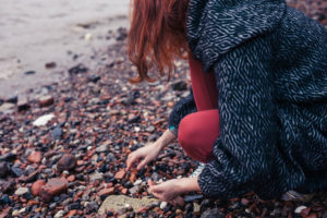 A photo of someone looking for sea glass along Outer Banks shores in winter.