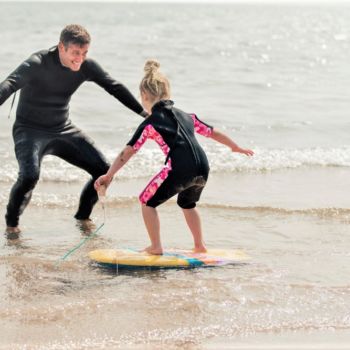Child receiving an Outer Banks surfing lesson